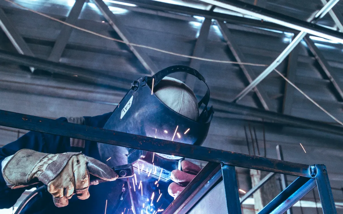 Metallbauer schweißt eine Stahlkonstruktion in der Werkhalle